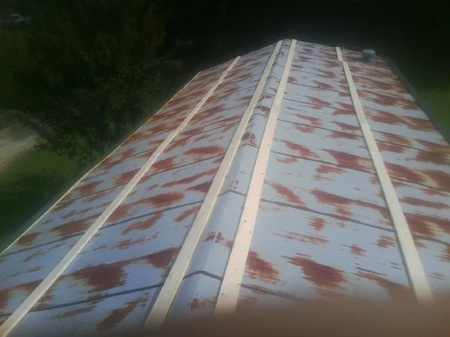 Rusted metal roof panels with new wood purlins before replacement — Storm Damage Roof Repair in North Clarendon by Roofing Brothers