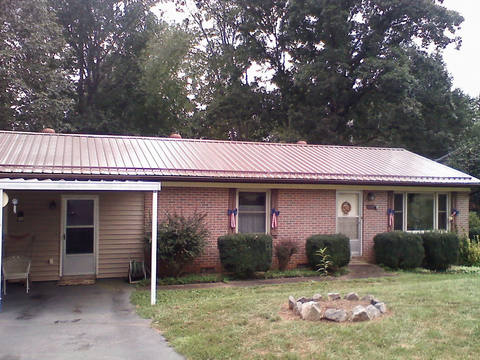 Bronze metal roof and carport on a brick ranch home — Roof Repair work by our crew in North Clarendon